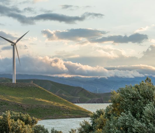 wind-power-turbine-hill-front-cloudy-sky